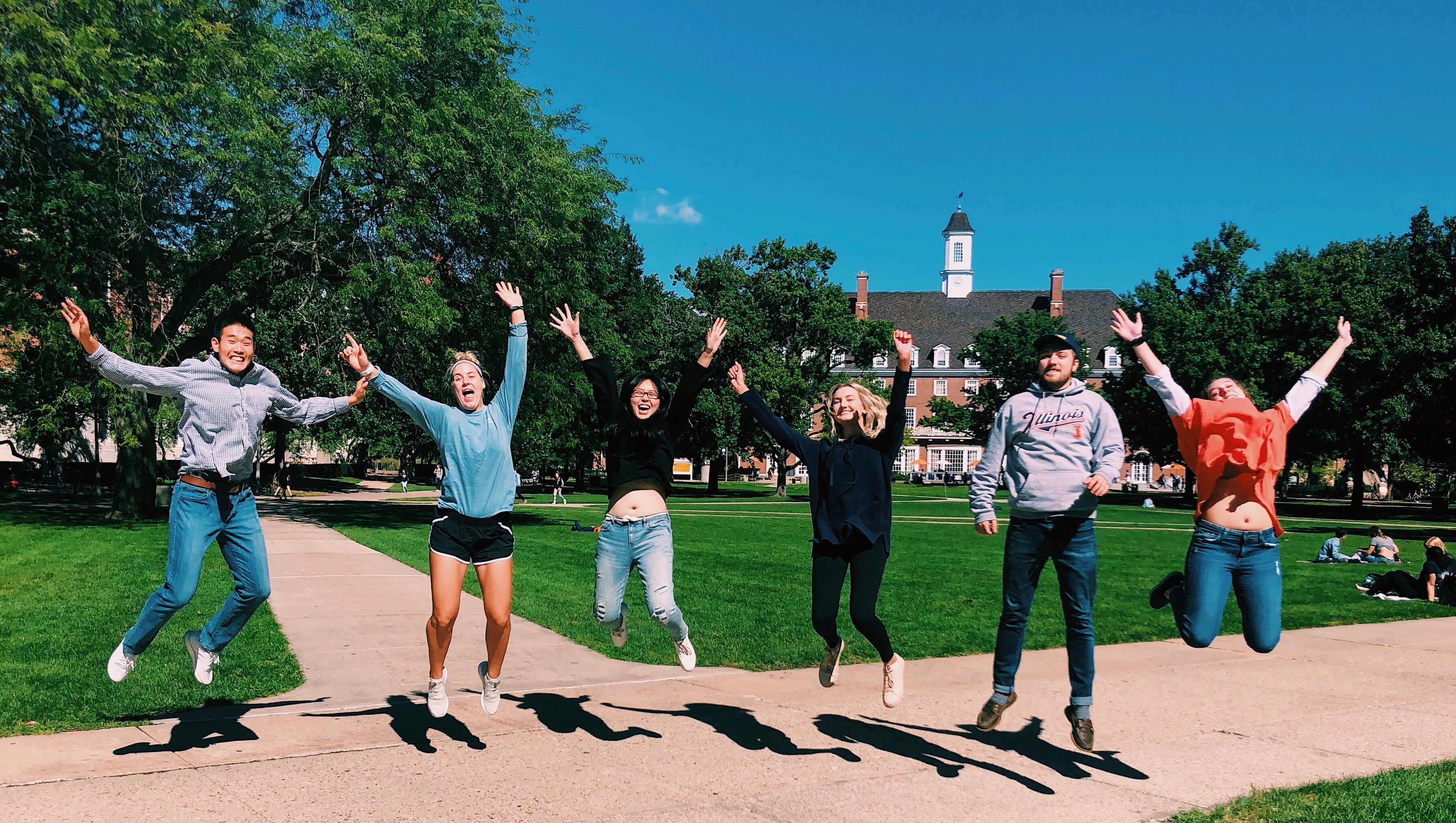 Six interns jumping in air in front of union